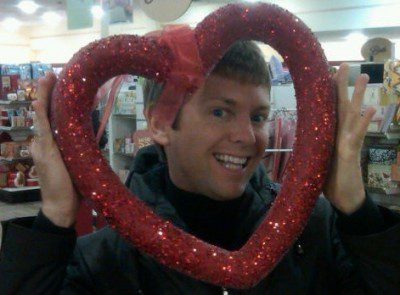 Person smiling through glittery heart frame