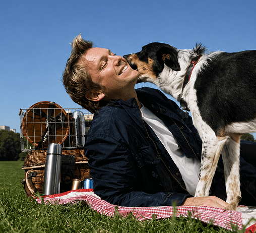 Dog licking man's face outdoors