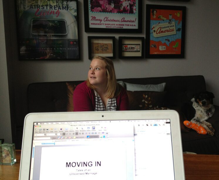 Woman sitting on couch behind laptop