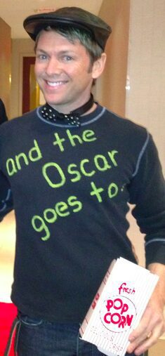 Man holding popcorn with Oscar-themed shirt