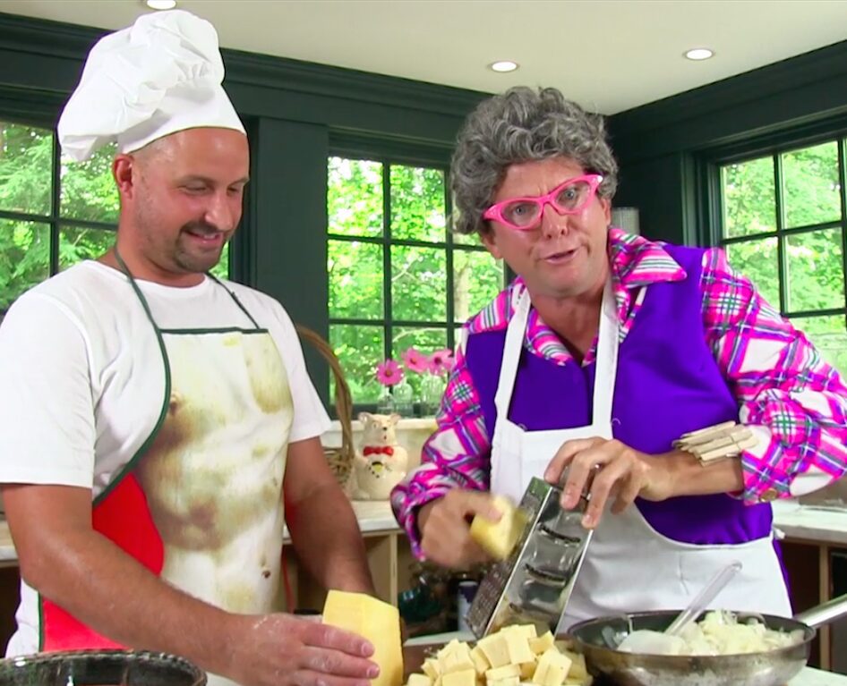 Duo preparing food with cheese and aprons