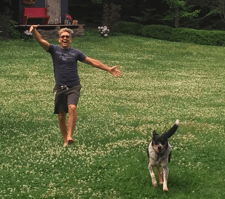 Happy person and dog in grassy field