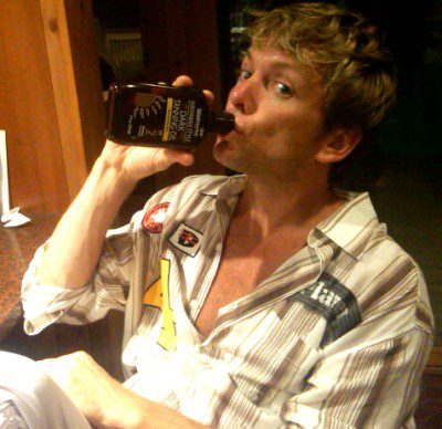 Man drinking from a bottle indoors