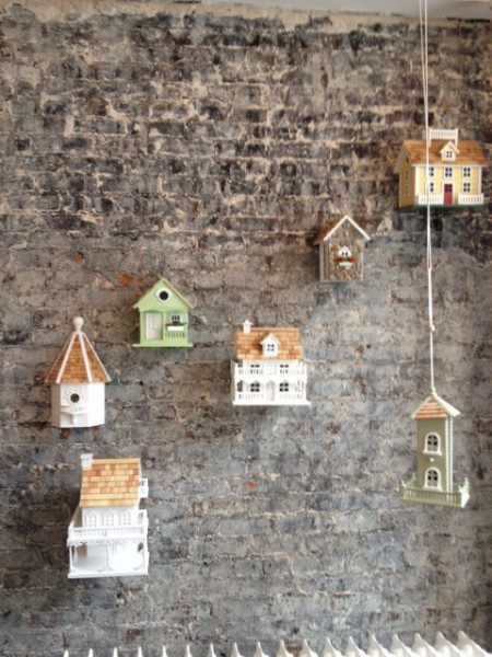 Decorative birdhouses on a brick wall