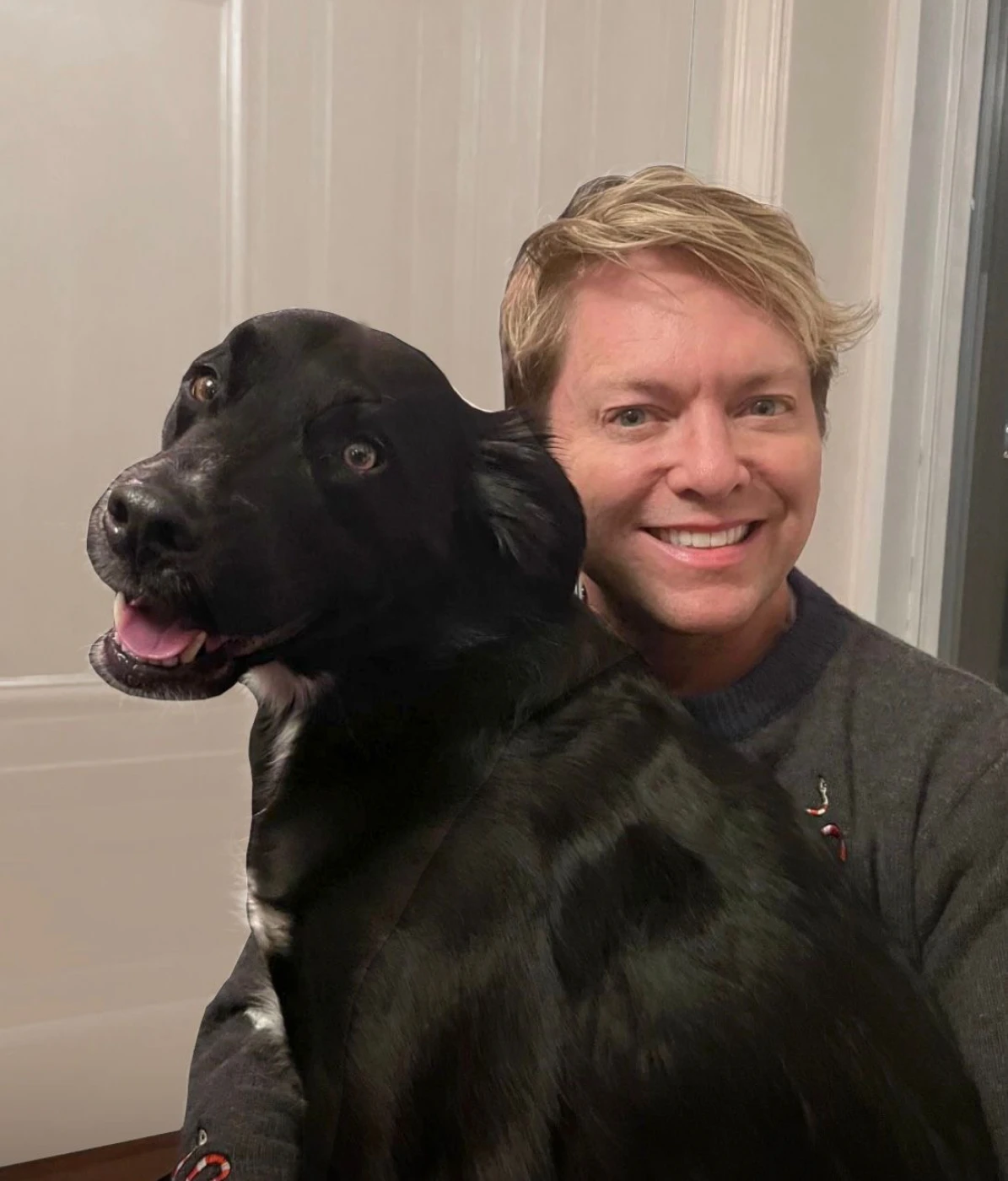 Person with cheerful black dog