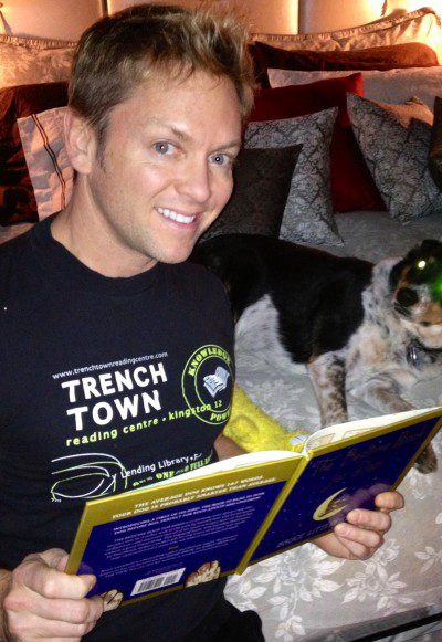 Smiling man with dog and book