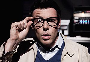 Man adjusting glasses, surprised expression