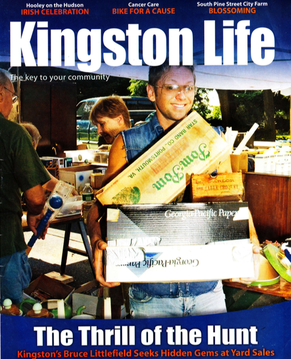 Man holding boxes at a yard sale.