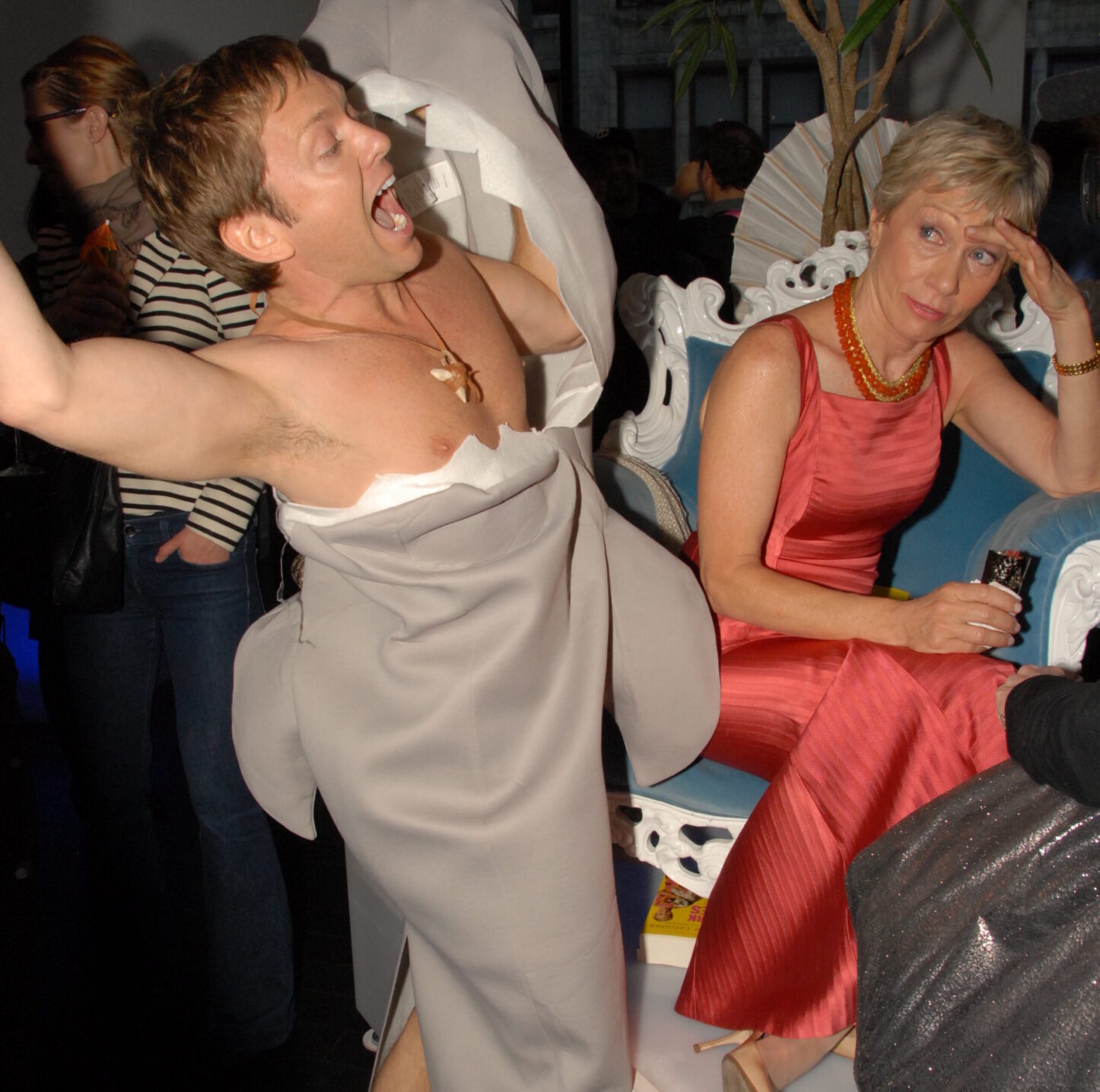 Man in shark costume, woman in red dress.