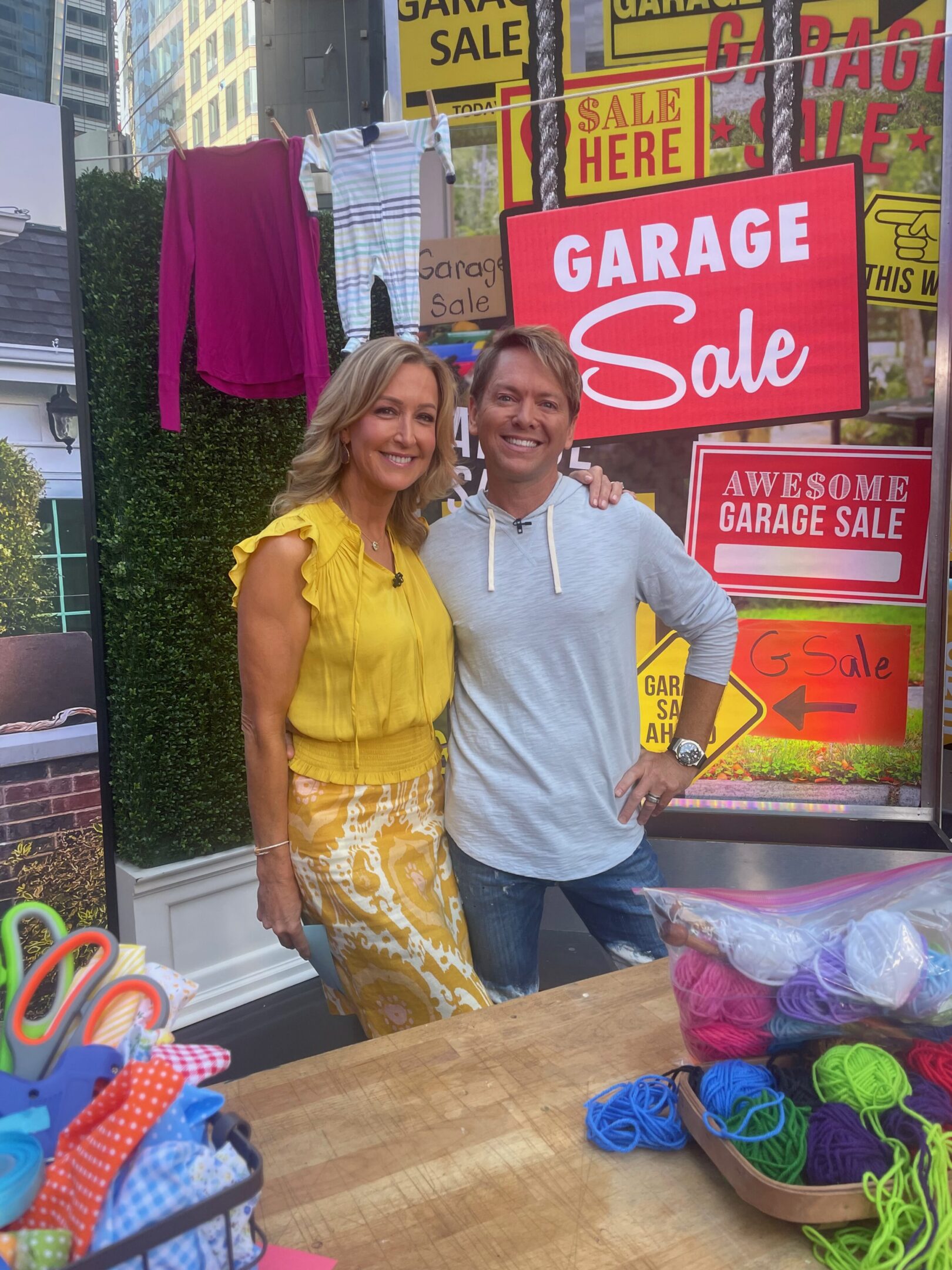 Two people smiling at a garage sale.