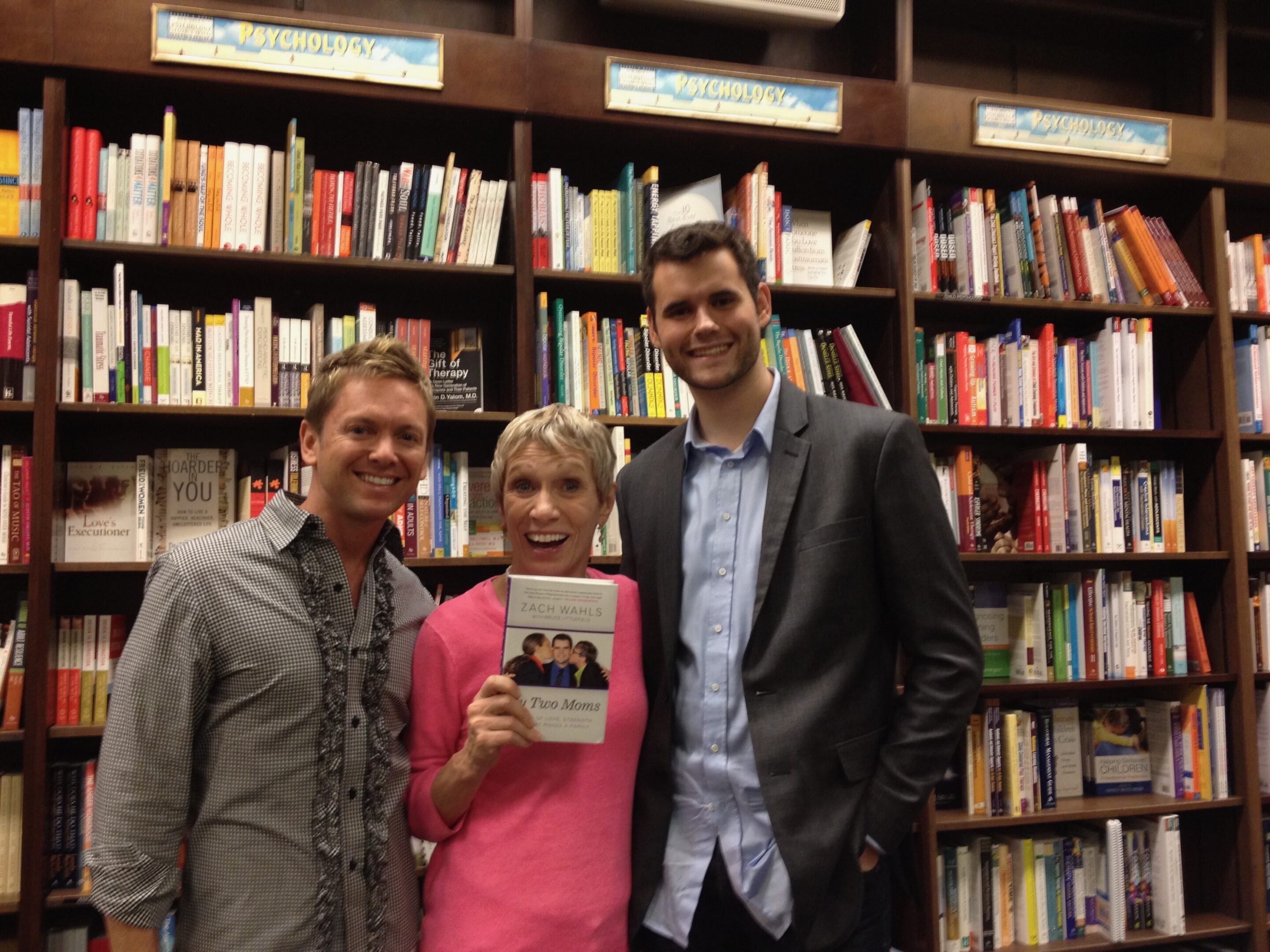 Three people posing in a bookstore.
