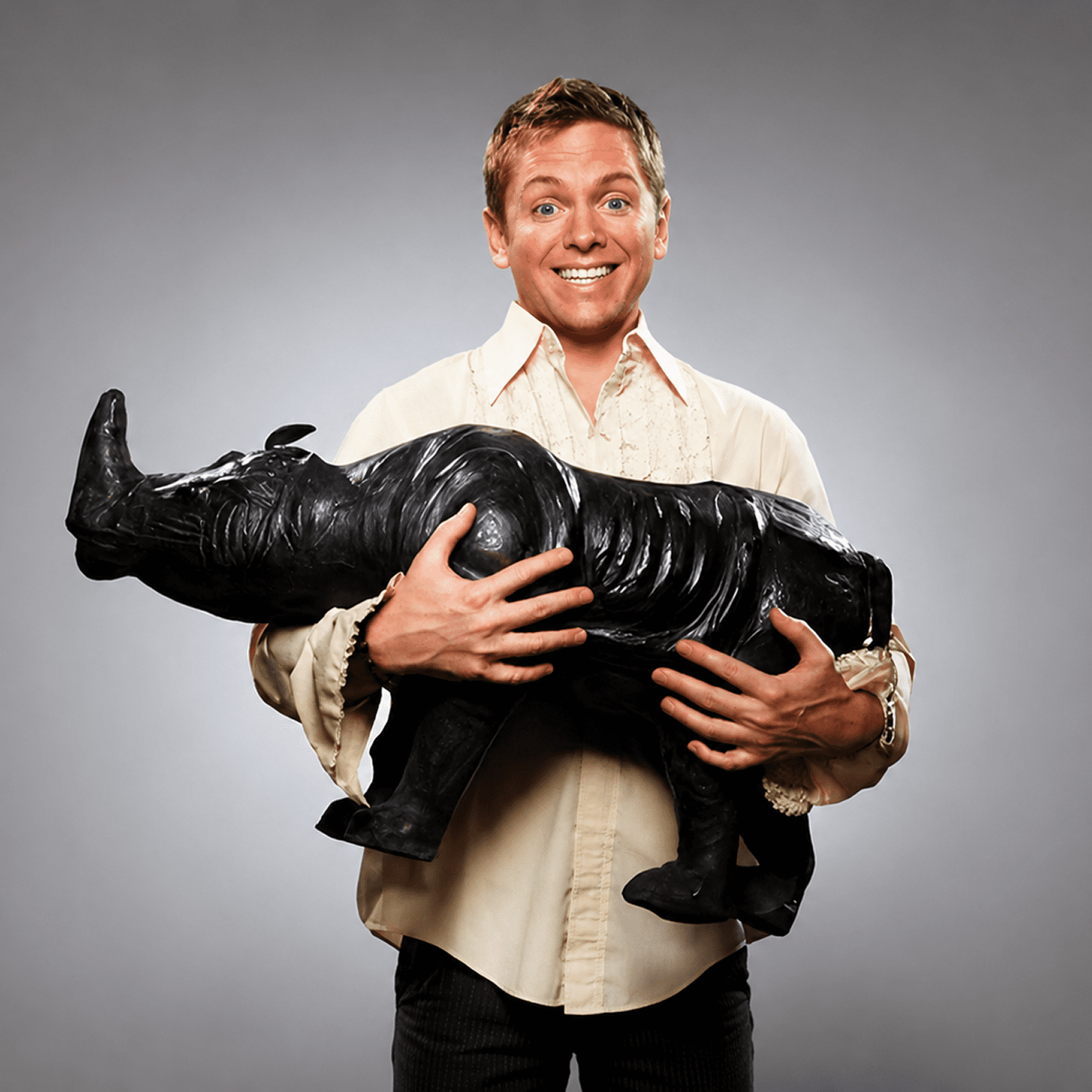 Person carrying a black rhino sculpture