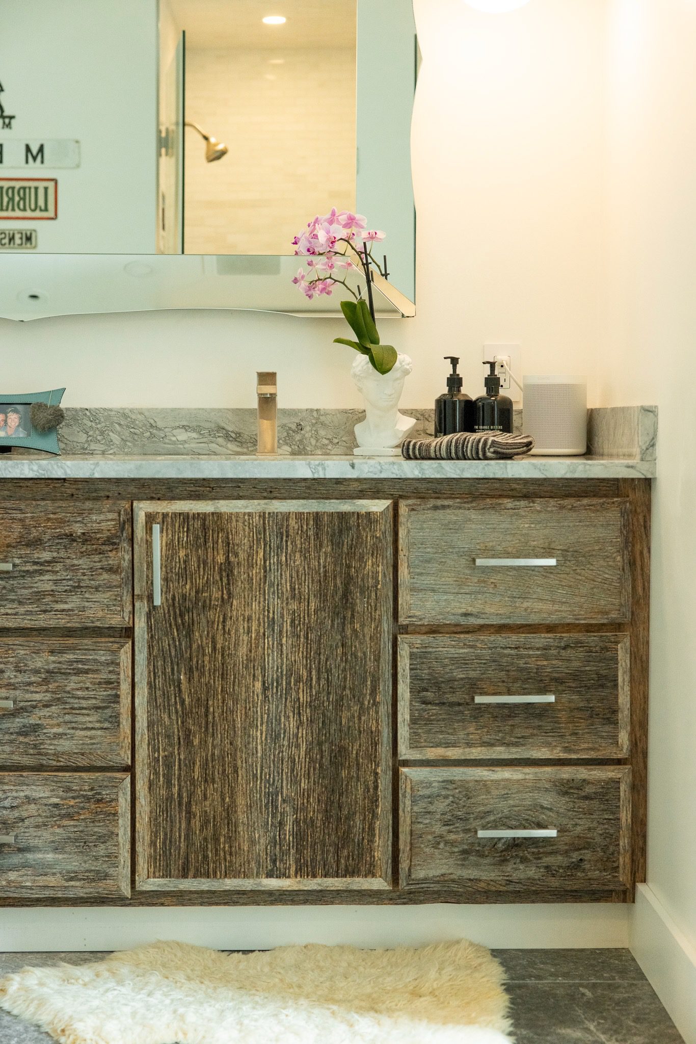 Bathroom vanity with orchid and mirror.