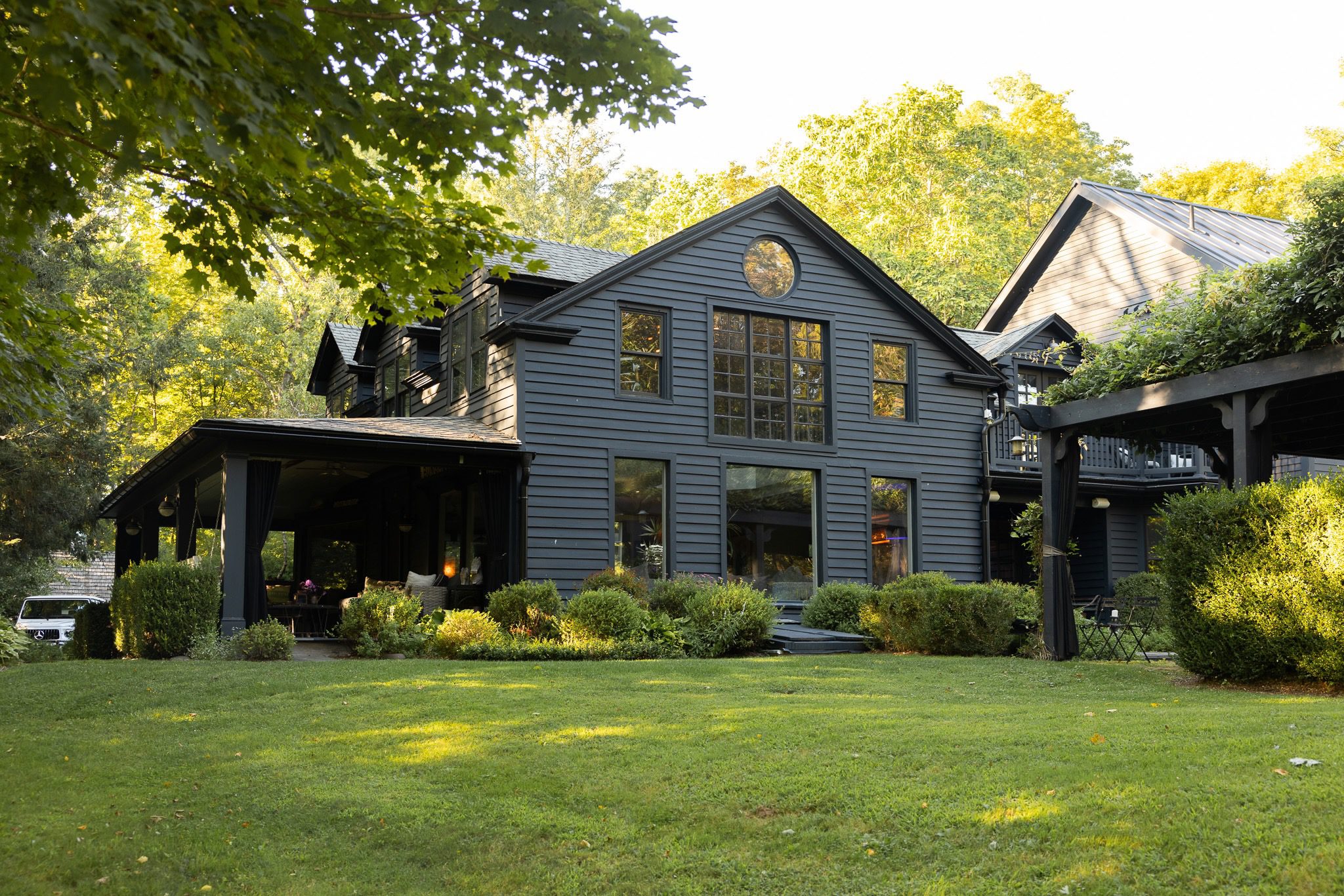 Dark house with green lawn and trees.
