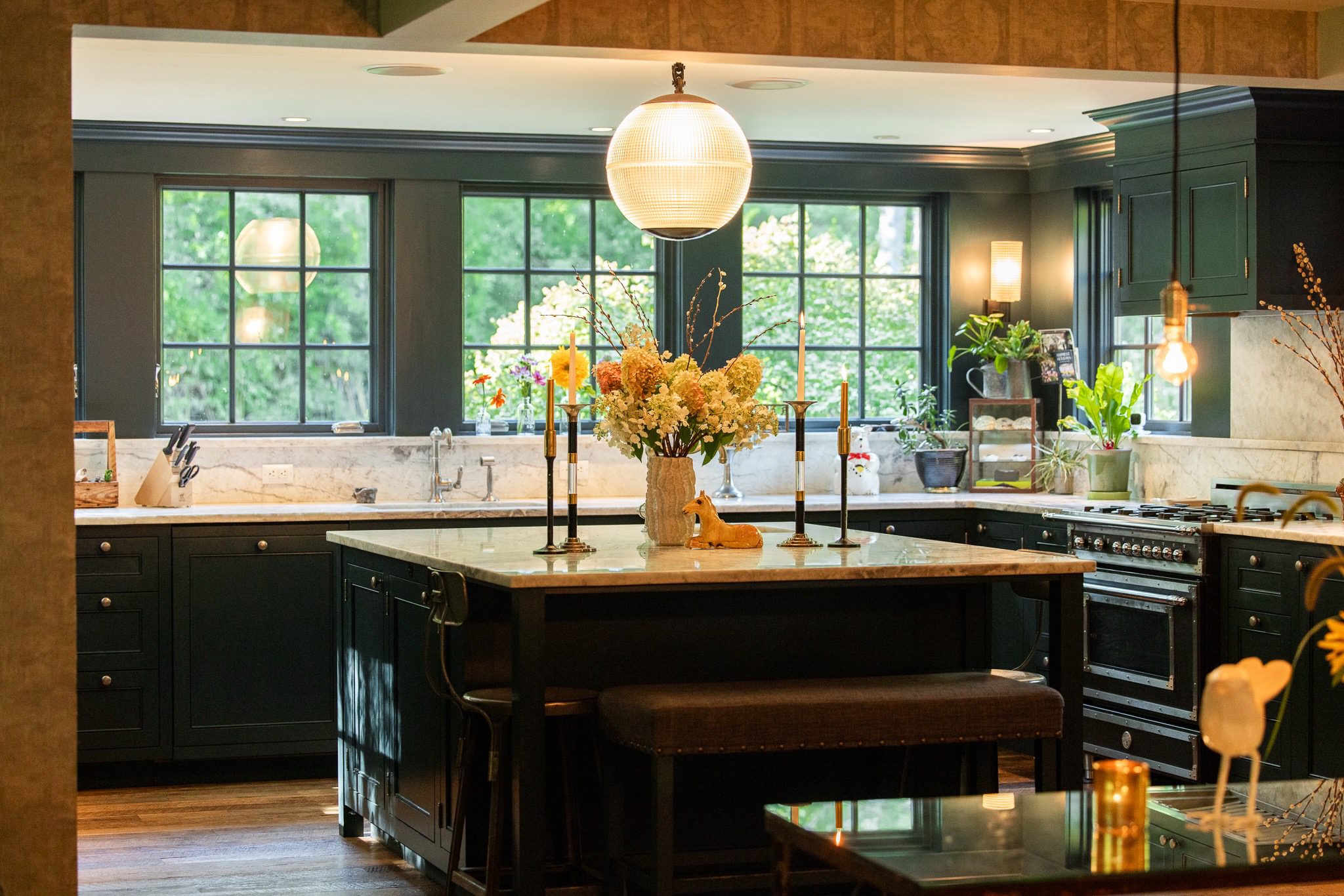 Modern kitchen with large island and flowers.