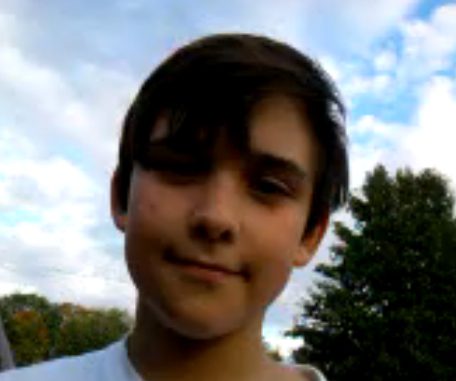 Young person outdoors, trees behind