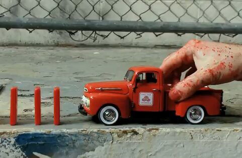 Red toy truck beside red sticks