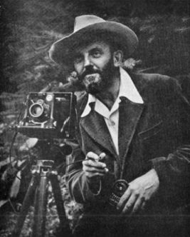 Photographer with camera and hat outdoors