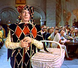 Medieval jester with basket indoors