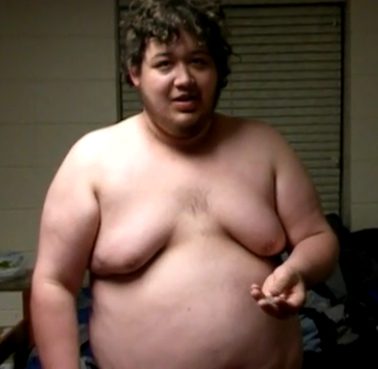 Man with curly hair, shirtless, indoors
