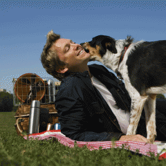 Dog licking man's face outdoors