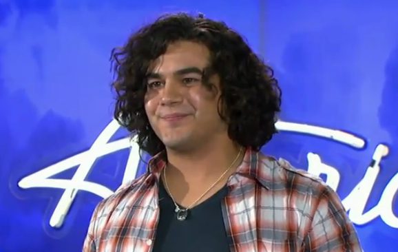 Person with curly hair on stage