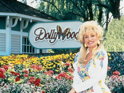 Woman smiling in front of Dollywood sign