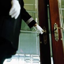 Gloved hand opening a glass door