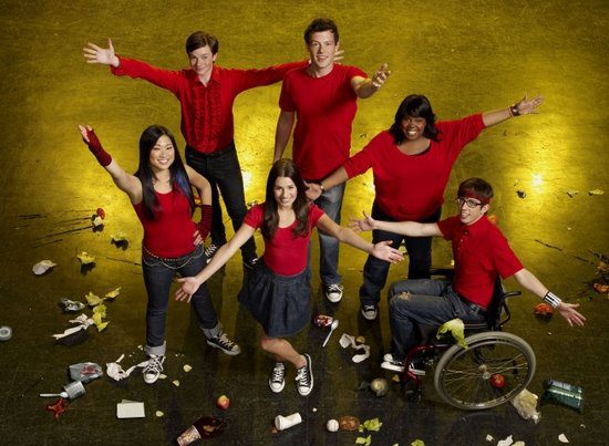 Six people posing on a messy floor