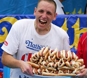 Enthusiastic participant with numerous hot dogs.