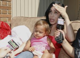 Press interviewing woman holding a toddler