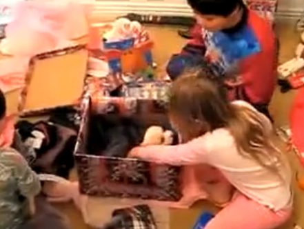 Youngsters exploring holiday gifts eagerly
