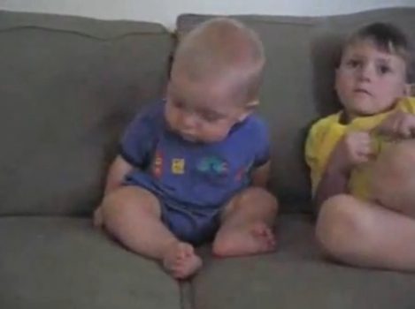Baby and child sitting on couch