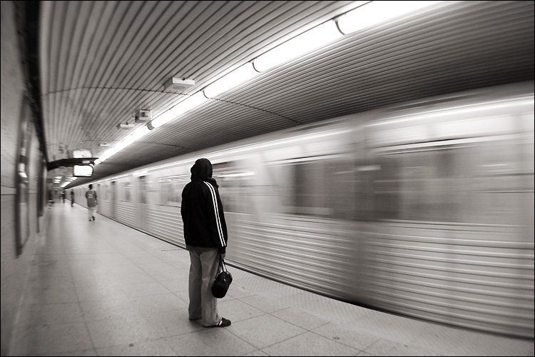 Person waiting as train speeds by