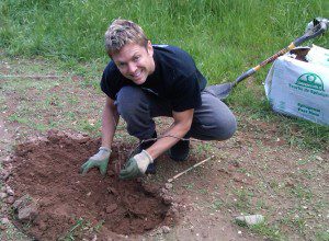 Smiling individual gardening with gloves