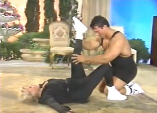 Man assisting woman with leg stretch
