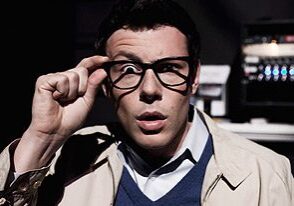 Man adjusting glasses, surprised expression