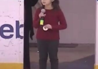 Girl holding microphone on rink edge