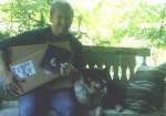 Person on bench with packages and dog