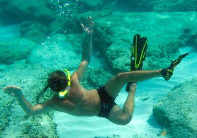 Snorkeler swimming underwater with fins