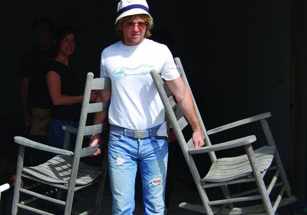 Person holding chairs in both arms