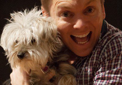 Joyful person cuddling a cute dog