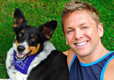 Man and dog smiling on grass