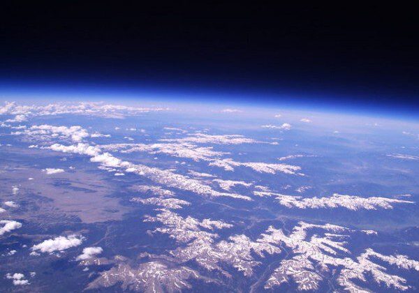 Earth's curvature with mountainous terrain below