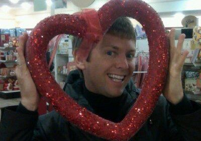 Person smiling through glittery heart frame