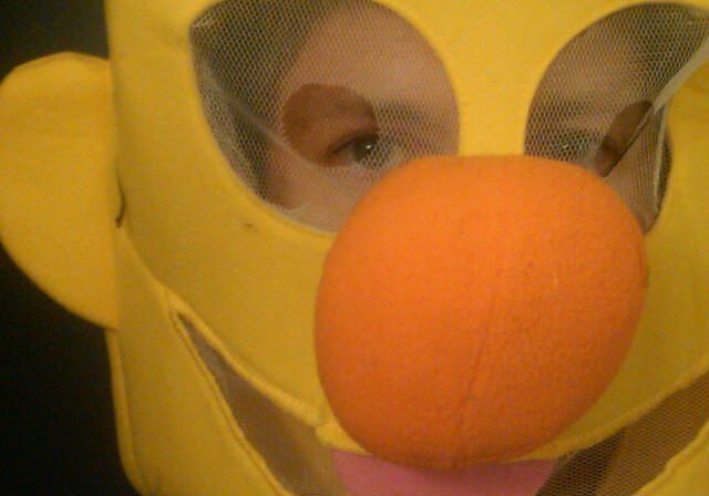 Child peering through character mask
