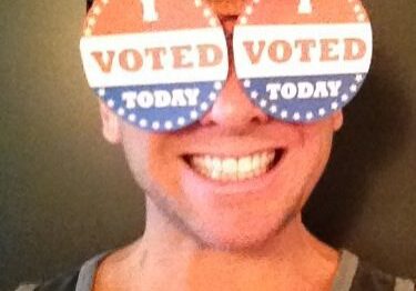 Smiling voter with novelty glasses