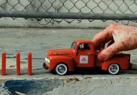 Red toy truck beside red sticks