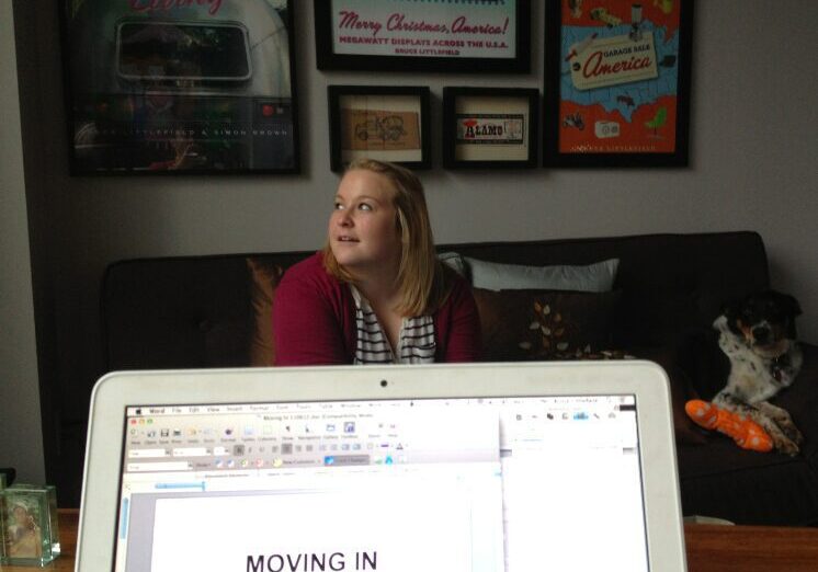 Woman sitting on couch behind laptop