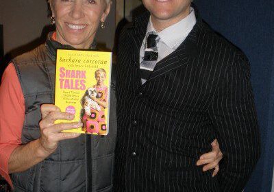 Woman holding a book, smiling with man
